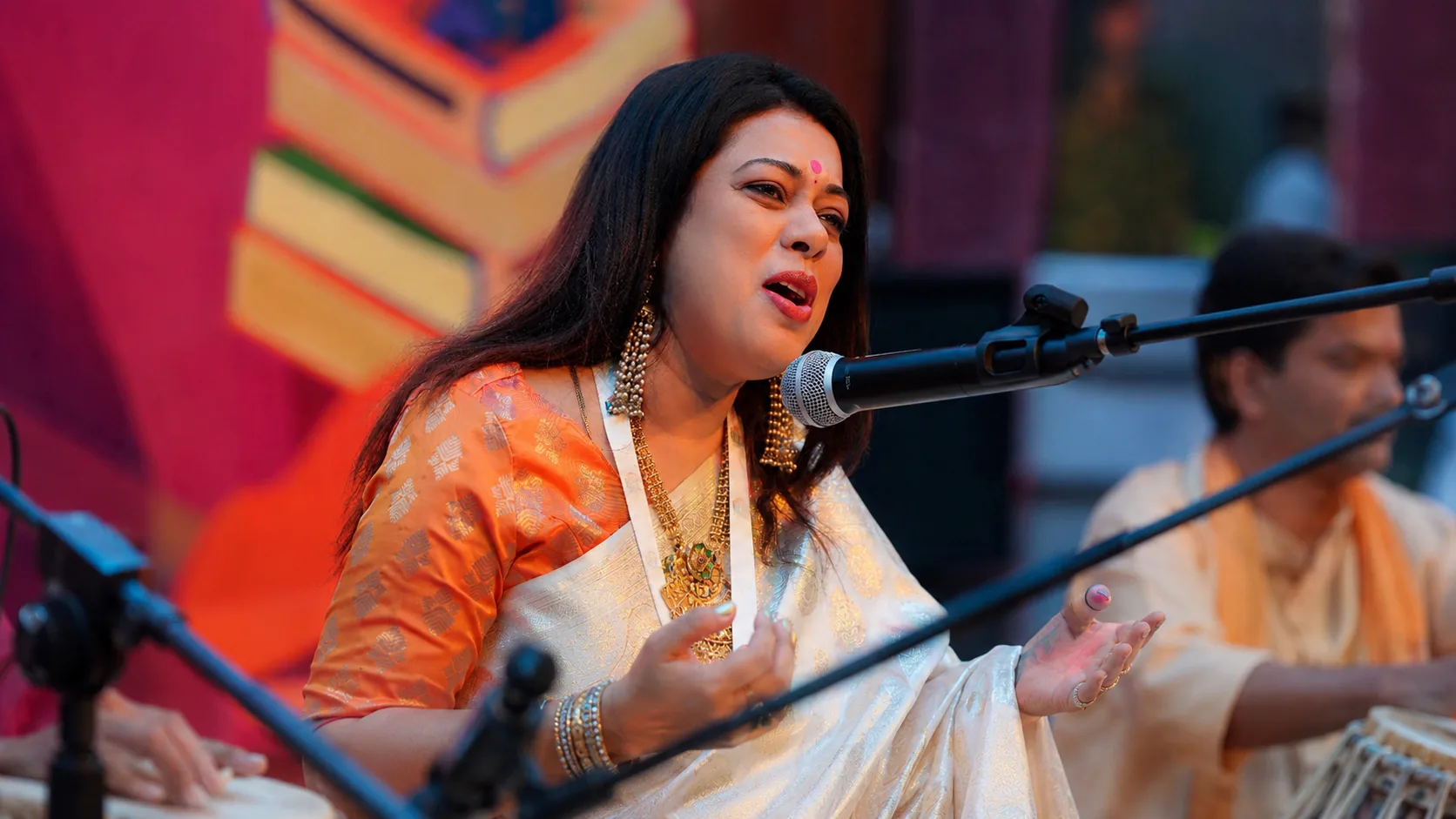 Barnali Chattopadhyay mid-phrase at the microphone, her tabla accompanist beside her